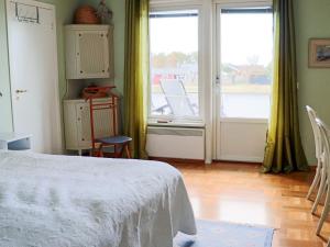 a bedroom with a bed and a balcony with chairs at 9 person holiday home in Skummeslövsstrand in Skummeslövsstrand