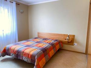 a bedroom with a bed with a colorful blanket at Sea House in Povoação