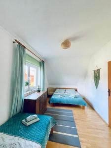 a bedroom with two beds and a window at Polańczyk Dom, Apartamenty - Leśny Domek Polańczyk in Polańczyk