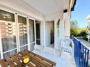 a porch with a wooden bench and chairs on a balcony at Apartsalou Blau Mari in Salou