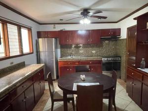 a kitchen with a table with chairs and a ceiling fan at Comparte con la Naturaleza in Escazu +25 photos