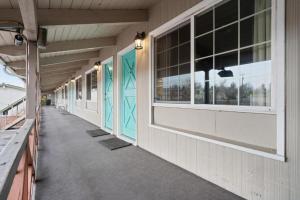 a hallway of a building with blue doors and windows at Silver Spur Motel in Burns