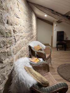a living room with a couch and a stone wall at Tracie's in Nanteuil-en-Vallée