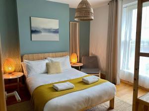 a bedroom with a bed with two pillows on it at Stylish & Spacious Town Centre Duplex Apartment in Porthmadog