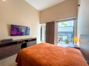 a bedroom with a bed and a flat screen tv at Departamento Morelos SLP Centro Historico in San Luis Potosí