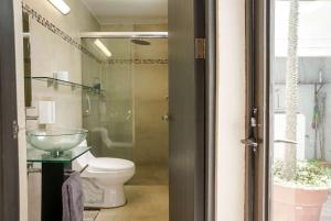 a bathroom with a toilet and a glass door at Departamento Morelos SLP Centro Historico in San Luis Potosí +23 photos