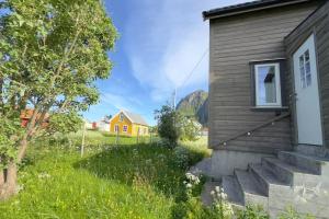 a house with stairs next to a building at Lofoten midnight sun spot house on the beach in Eggum