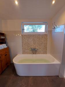 a large bath tub in a bathroom with a window at BB-4u in IJsselstein