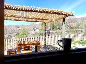 a window with a view of a wooden pergola at Cabañas Rowal Malbec Potrerillos in Potrerillos +24 photos