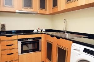 a kitchen with a sink and a dishwasher at Nooh Apartment in Al Ḩadd