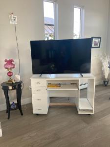 a white desk with a large tv on top of it at EdgeWater Chemainus in Chemainus