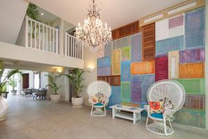 a room with a colorful wall with chairs and a chandelier at Sugar Bay Barbados - All Inclusive in Bridgetown