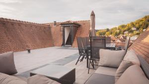 patio con divano, tavolo e ombrellone di 140qm Luxuriöses Penthouse mitten in Schwäbisch Gmünd, 70qm Dachterrasse & Top-Lage, mit WHIRPOOL, Jetzt buchen! a Schwäbisch Gmünd