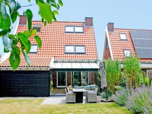 a house with an orange roof and a patio at Villa in Zeeland near Clean Beaches in Colijnsplaat