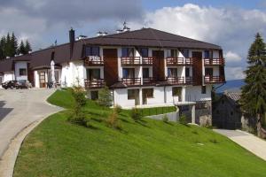 a large building on top of a green hill at Zimska bajka in Gornja Šišava