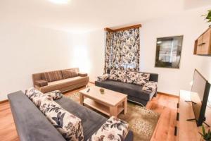 a living room with a couch and a table at Zimska bajka in Gornja Šišava +4 photos