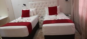 2 posti letto in una camera con rosso e bianco di Rest & Digest a Serowe