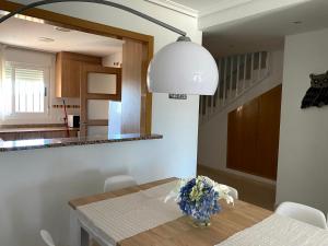 a kitchen with a table with a vase of flowers on it at Duplex Torre la Sal Magic World La Tormesilla in La Estación +16 photos