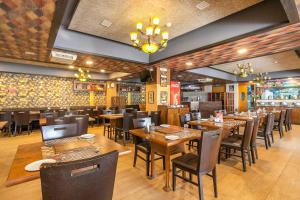 a dining room with wooden tables and chairs at Collection O Indian Suites Near Sitara Restaurant in Bengaluru