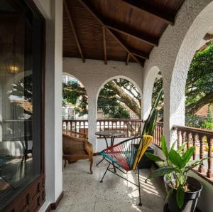 a patio with a chair and a table on a porch at Colonial Villa in Laureles, Unique&Special House in Medellín