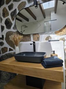 Un baño con un lavabo negro sobre una mesa de madera. en La Cabaña Del Sol, en La Asomada 15 fotos más