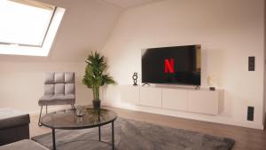 un soggiorno con una TV a parete di 140qm Luxuriöses Penthouse mitten in Schwäbisch Gmünd, 70qm Dachterrasse & Top-Lage, mit WHIRPOOL, Jetzt buchen! a Schwäbisch Gmünd