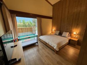 a bedroom with a bed and a large window at Villa Pirin Golf in Bansko