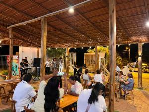 a group of people sitting at tables in a pavilion at Ohana Beach Hotel in Playas