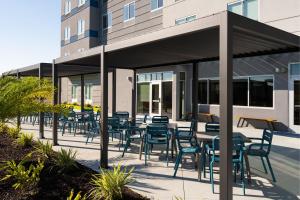 a patio with tables and chairs in front of a building at Fairfield by Marriott Inn & Suites Waycross in Waycross