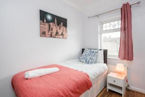 a bedroom with a bed and a window at Everything You Need I Super Comfy I Sleeps 7 I WiFi I Parking I 4BDR in Dagenham