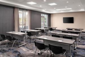 a classroom with tables and chairs and a flat screen tv at Fairfield by Marriott Inn & Suites Waycross in Waycross