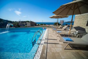 ein Swimmingpool mit Liegestühlen und einem Sonnenschirm in der Unterkunft Exclusive Hotel in Budva