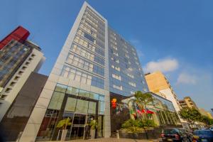 a tall building with a red traffic light in a city at Sol de Oro Hotel & Suites in Lima