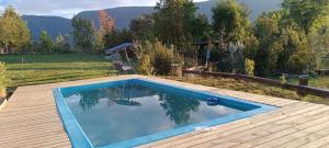 a swimming pool on a wooden deck next to at Hostel Calafquen Adventure Coñaripe in Coñaripe