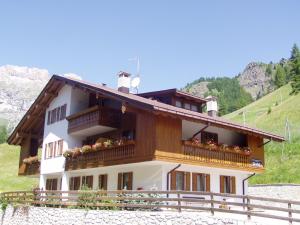 une maison avec deux personnes debout sur le toit dans l'établissement Chalet Pradat, à Arabba