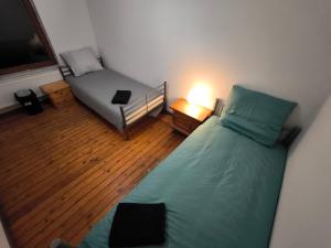 a bedroom with a bed and a couch and a lamp at Maison entière privée in Charleroi