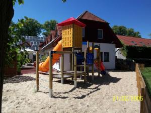 een speeltuin met een glijbaan in het zand bij Landhotel zum Baggernpuhl in Wachow