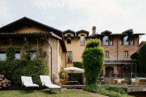 una casa con due sedie e un ombrellone davanti di Hotel Casa Pavesi a Grinzane Cavour