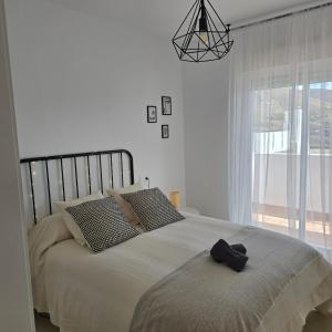 a bedroom with a bed with a black object on it at Casa Serena Alojamiento Rural in Enix