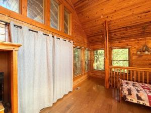 a large wooden room with white curtains in a cabin at great escape in Sevierville