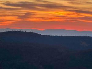 a sunset in the mountains with trees in the foreground at SRC-Hudson Valley, Berkshires Cultural Corridor in Canaan