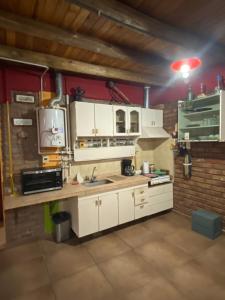 eine Küche mit weißen Schränken und einer Spüle in der Unterkunft CASA RINCON DE VISTALBA in Vistalba