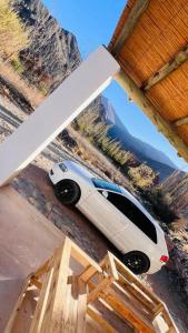 a white car is parked under a roof at Cabaña la Viña in Purmamarca