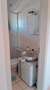 un bagno bianco con un water e un lavandino di Apto 2 Dorm Vista para Mar a Capão da Canoa Altre 13 foto