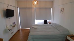 a bedroom with a bed in a room with a window at Departamento Céntrico Frente al Mar y con Cochera in Puerto Madryn