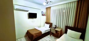ein Hotelzimmer mit Bett und Fernseher in der Unterkunft WİND HOTEL in Sakarya