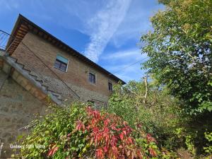 un edificio de ladrillo con plantas rojas delante de él en Podere Ponticini, en Siena