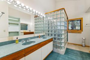a bathroom with two sinks and a glass wall at New! Birch Fairway House - On golf course - Hot tub - Garage - Family friendly in McCall +38 photos