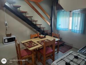 a dining room with a table and chairs and a staircase at El depto de mirta 964 Esquiu in San Bernardo