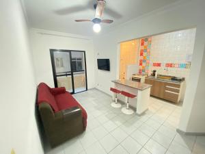 a living room with a couch and a kitchen at Pé na areia praia da Guilhermina III in Praia Grande